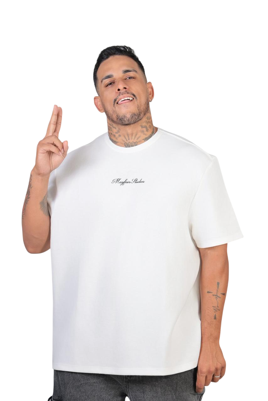 Cantor Roger Matos, de camiseta branca, sorrindo e fazendo um gesto com dois dedos